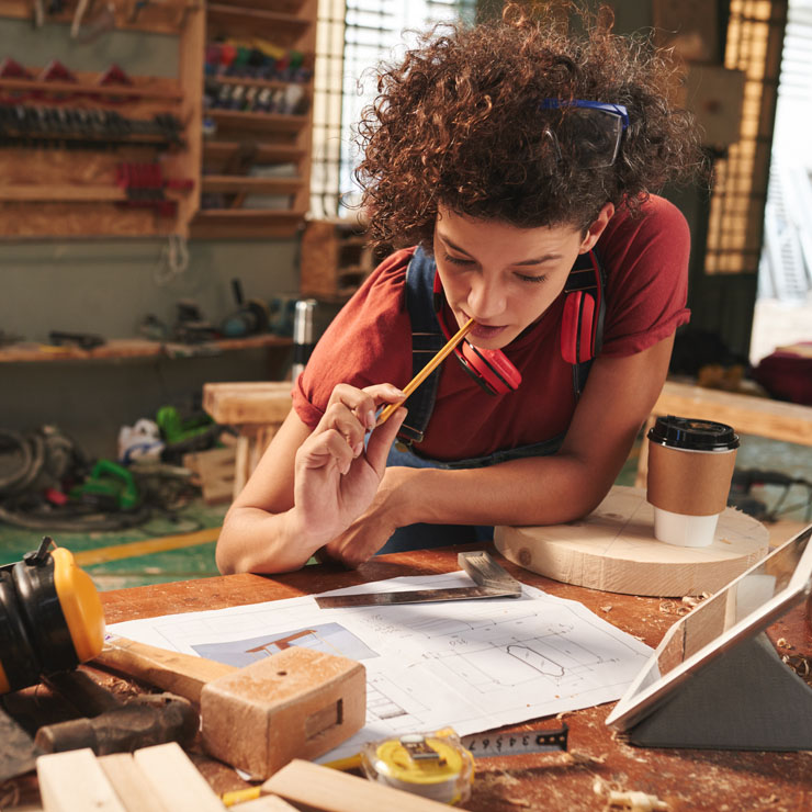 Woman looking over diagrams as she thinks.