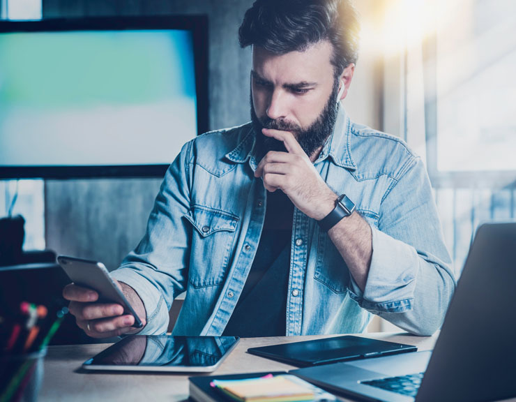 Man looking at phone and thinking.